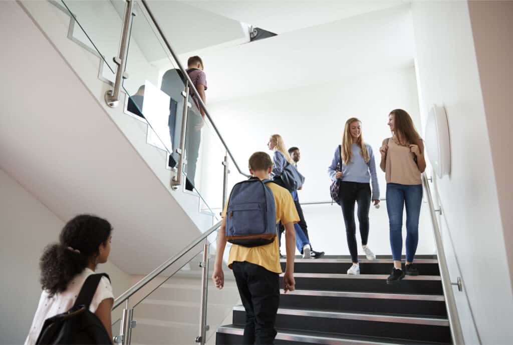 This images show students walking on a staircase in a high school.