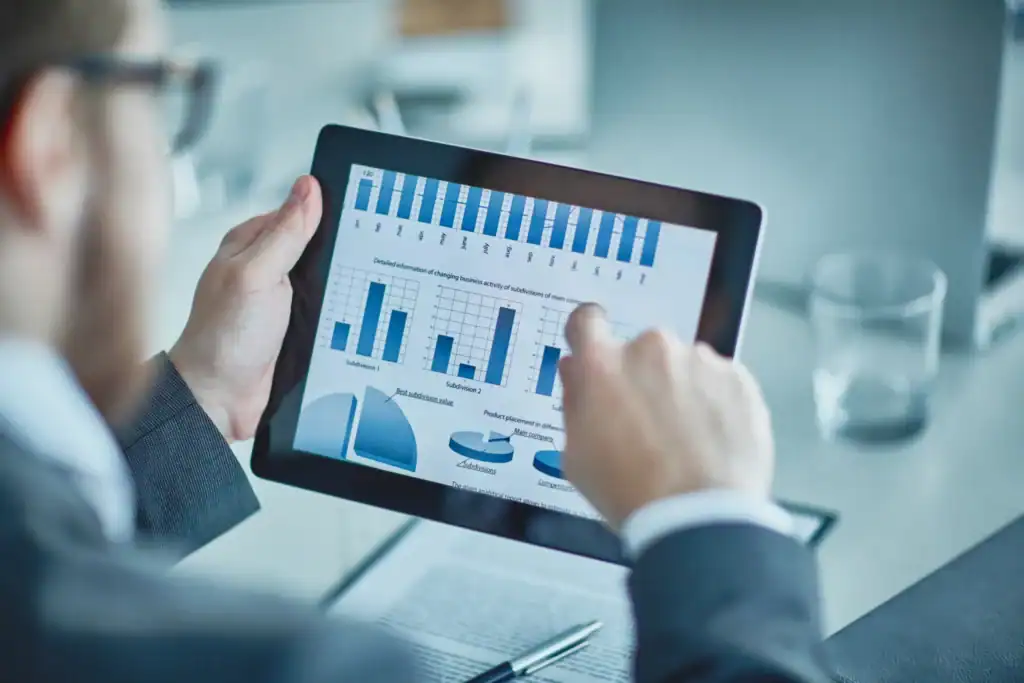 A stock image of someone pointing at a data collection chart on an ipad.