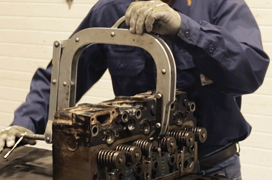 Mesa Power Solutions employee disassembles the head of an engine for remanufacturing.