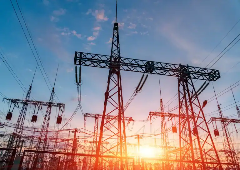 The image shows the contrast between traditional energy service providers and advanced power solutions through the use of power transformers with the sunsetting in the background.