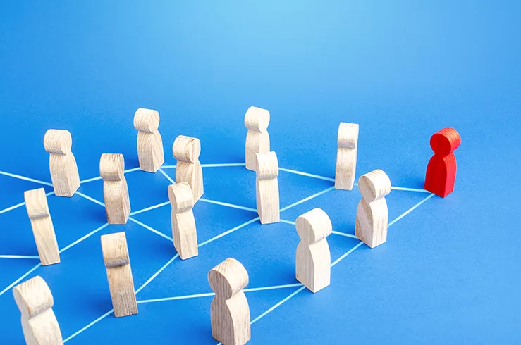 A web of wooden people figures show how a team in connected and managed well under a good leader. This is from the Rules of Leadership and demonstrates teamwork.