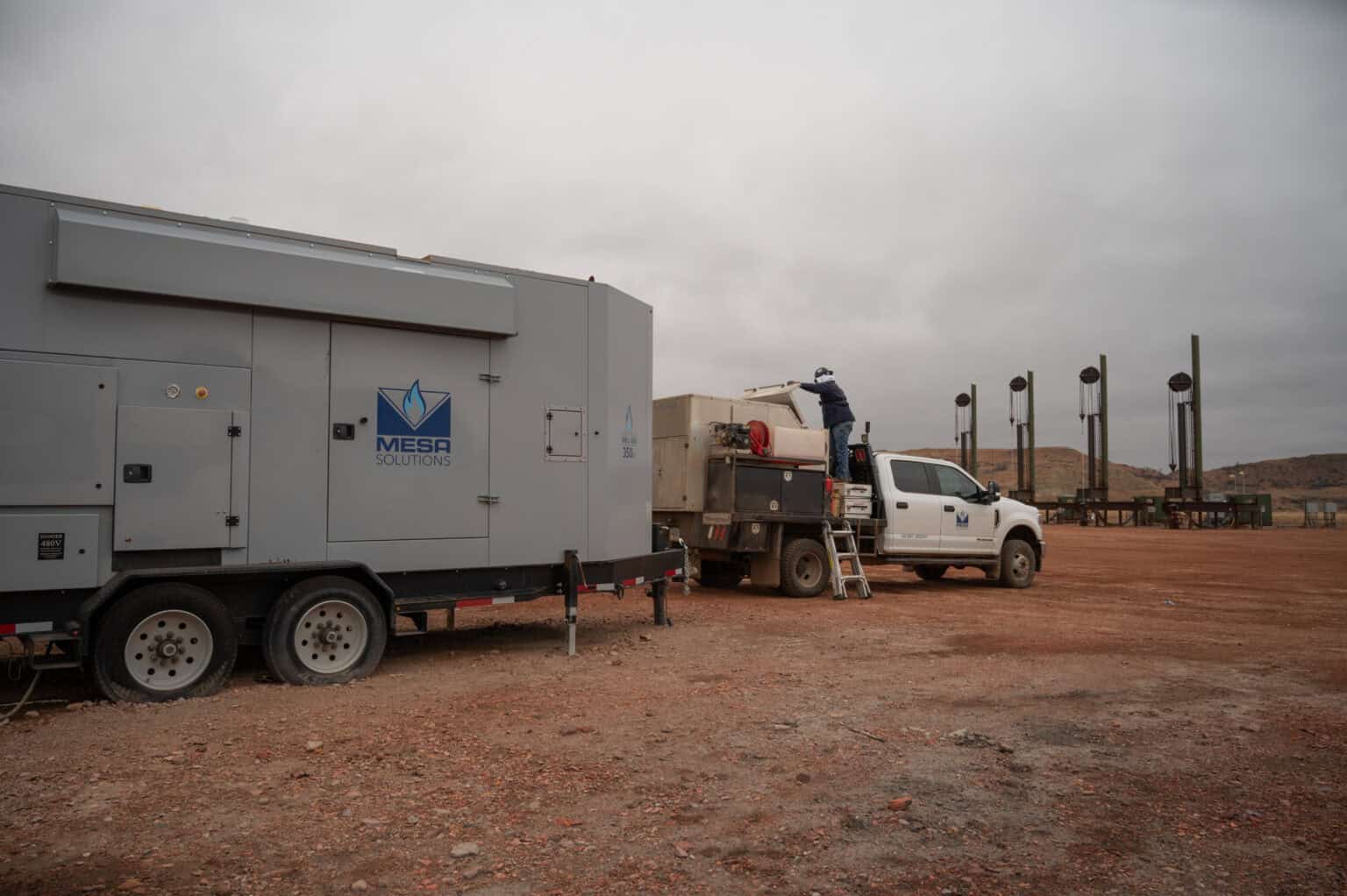 A Mesa Power Solutions generator trailer and service truck positioned on-site under overcast skies, showcasing dependable mobile power systems and dedicated field service for industrial energy operations.