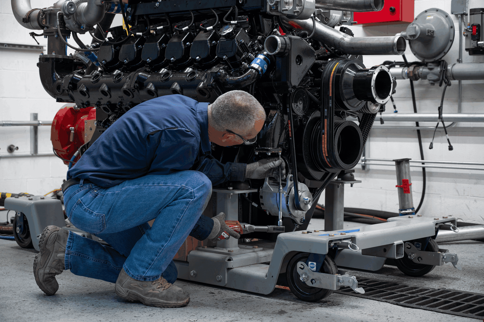 Mesa Power Solutions assembly technician working on an engine with a ratchet.