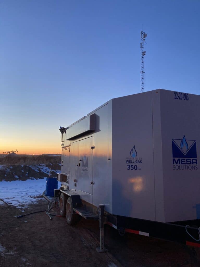This image shows a picture of a mobile natural gas generator from Mesa Power Solutions with a sunset in the background.