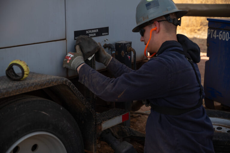 Gen tech using full safety gear to work on a scrubber drain