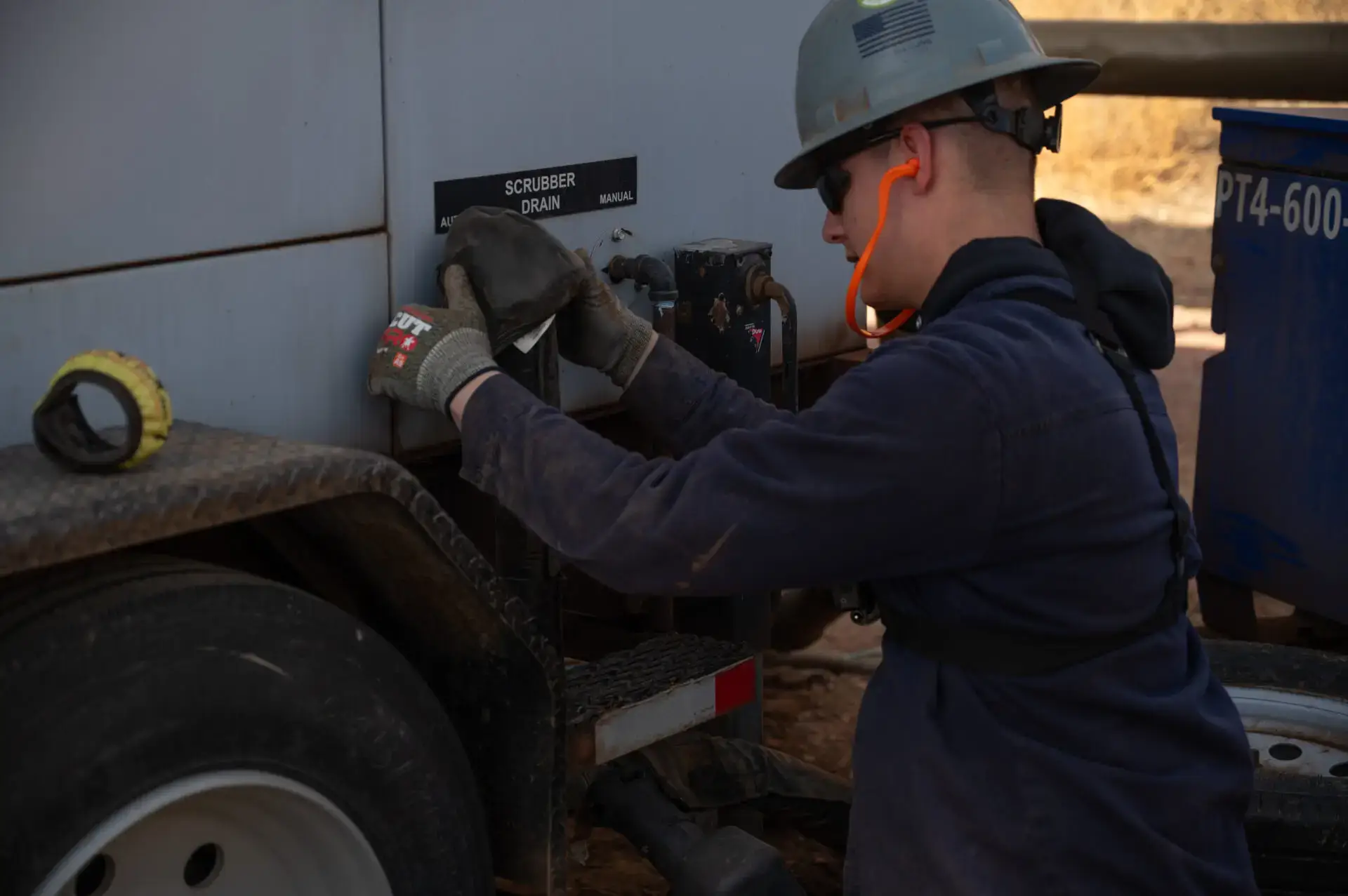 Gen tech using full safety gear to work on a scrubber drain